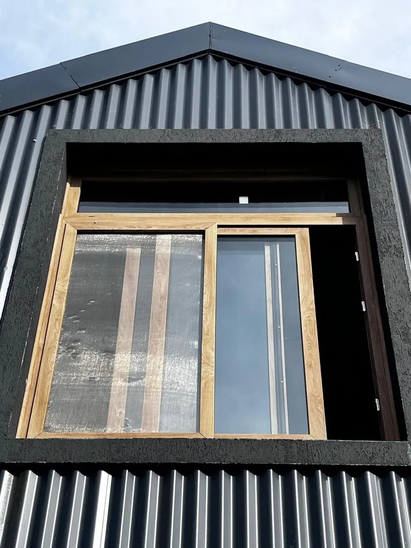 Ventana corrediza de PVC Turner con banderola fija en el hastial de la casa