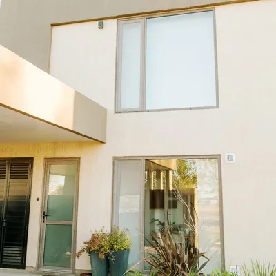 Ventana alta de PVC Monument en planta alta y puerta con postigón de celosía