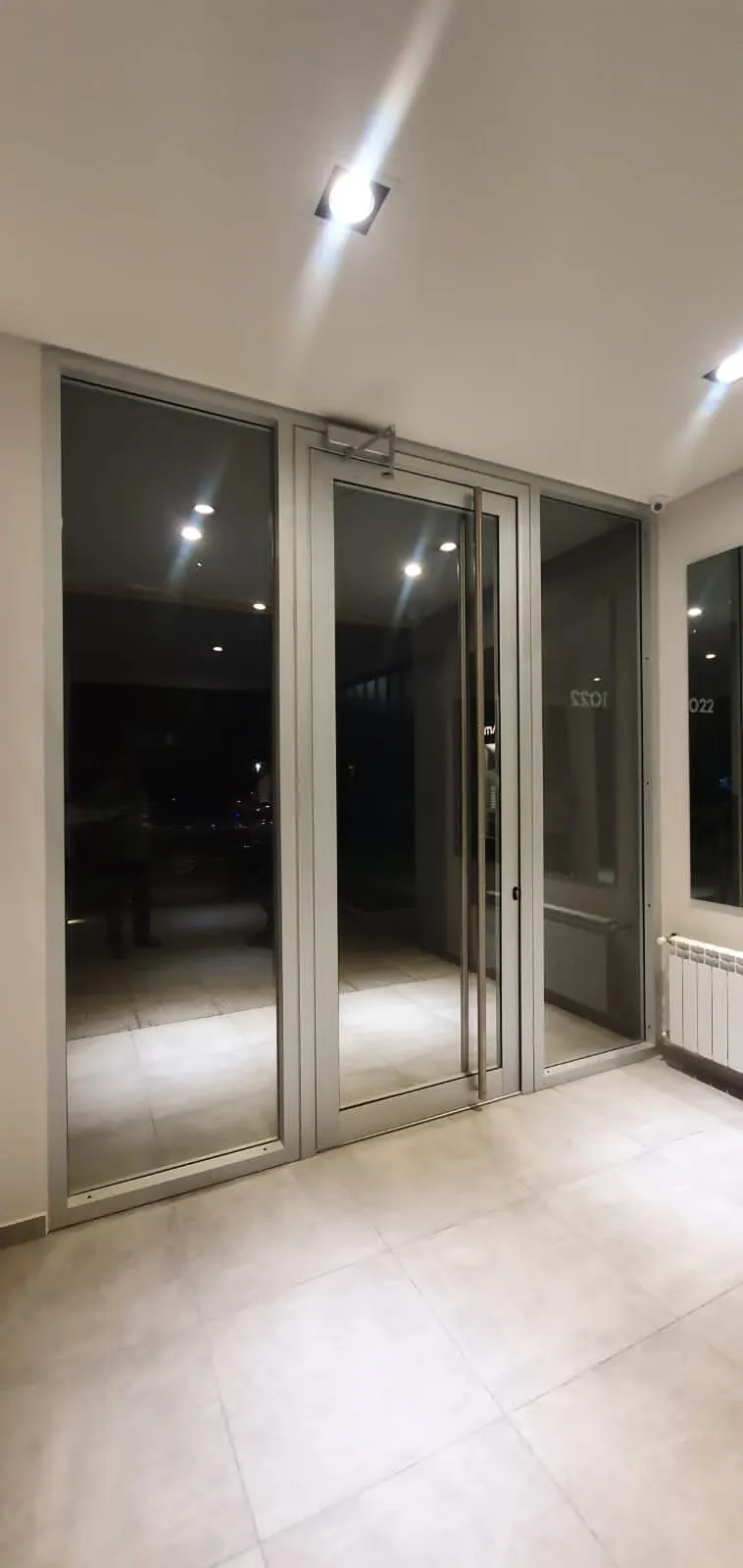 Puerta de aluminio con dos paños fijos a los laterales