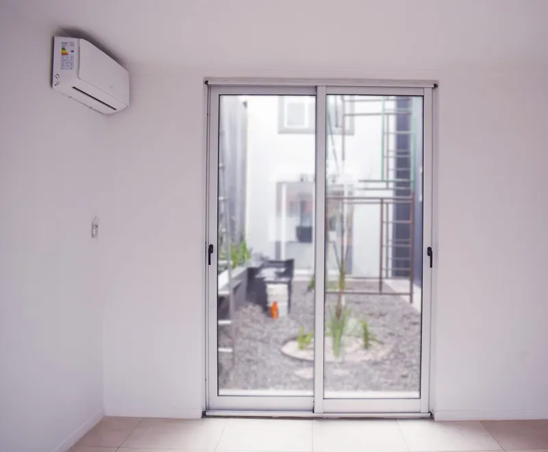 Puerta ventana corrediza de aluminio blanco con salida al patio