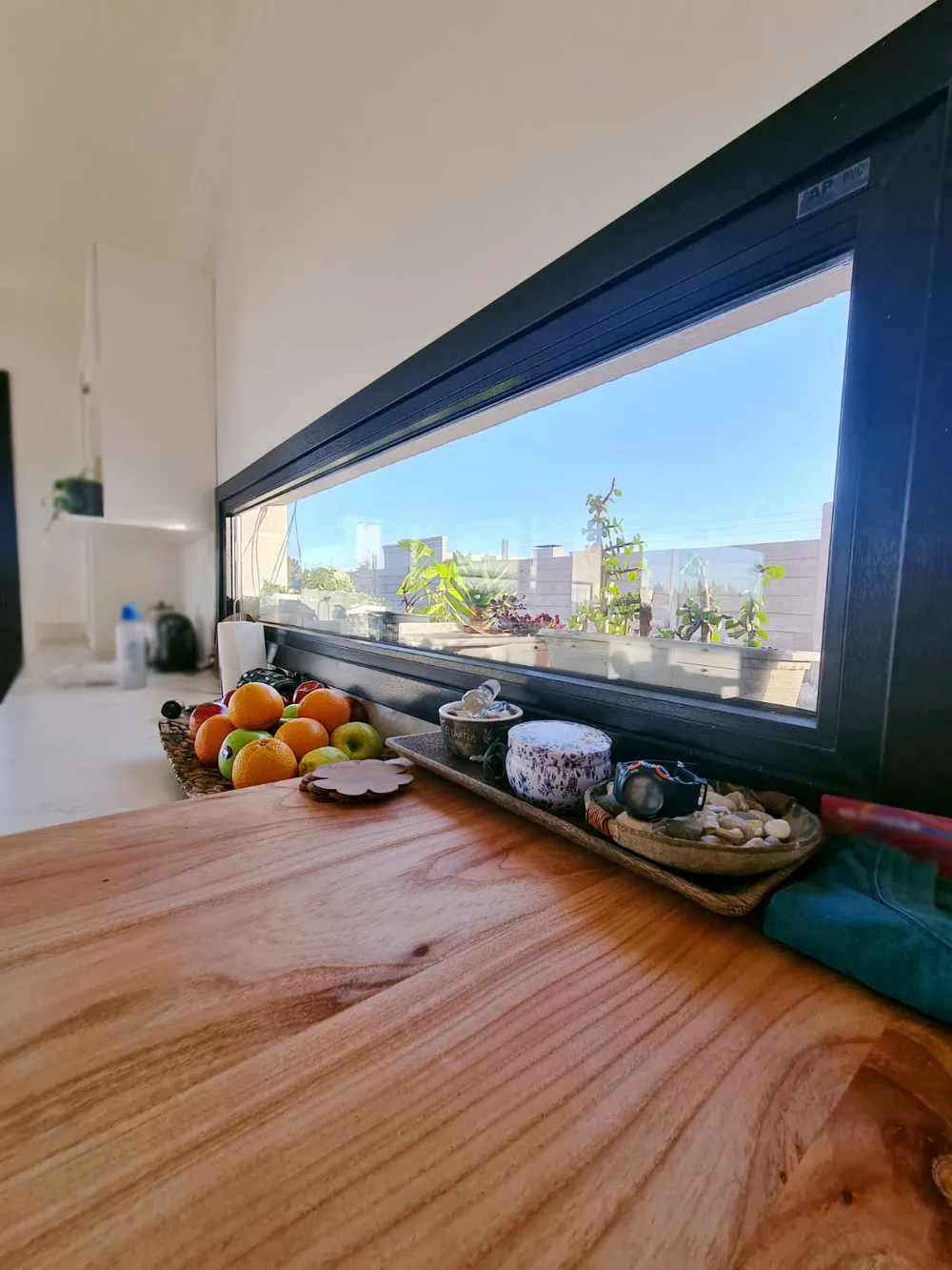 Ventana apaisada de PVC negro sobre la mesada de la cocina en Trenque Lauquen