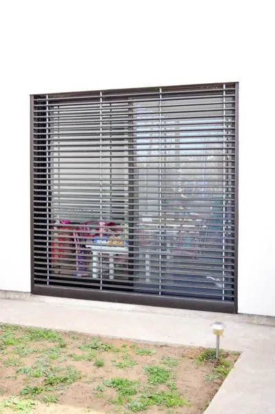 Celosía de aluminio anodizado negro bajada sobre el ventanal