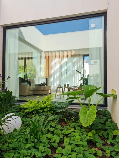 Vista del living a través de los paños fijos de aluminio black brown del patio