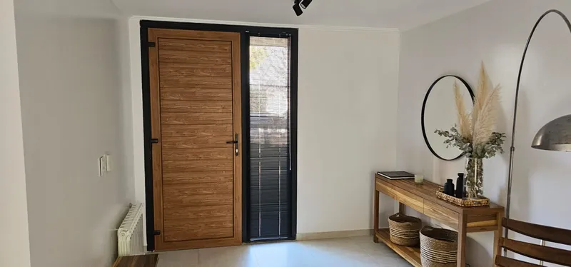 Hall de entrada con puerta de PVC Winchester y paño fijo lateral negro mate