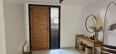 Hall de entrada con puerta de PVC Winchester y paño fijo lateral negro mate