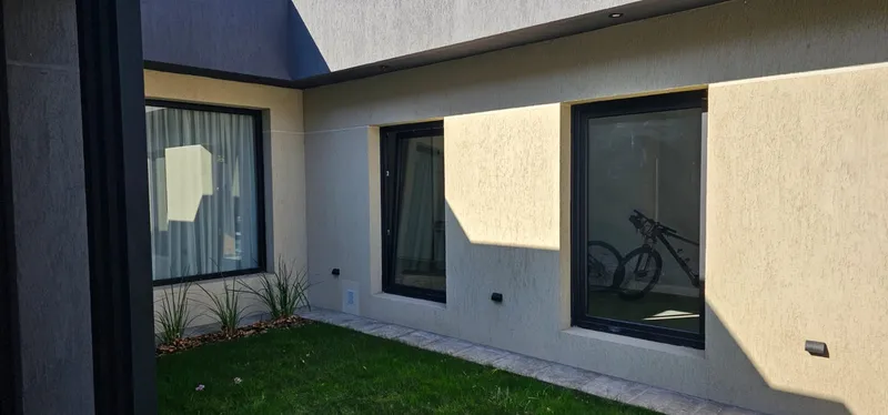 Frente al patio con ventanas de PVC negro mate de gran superficie