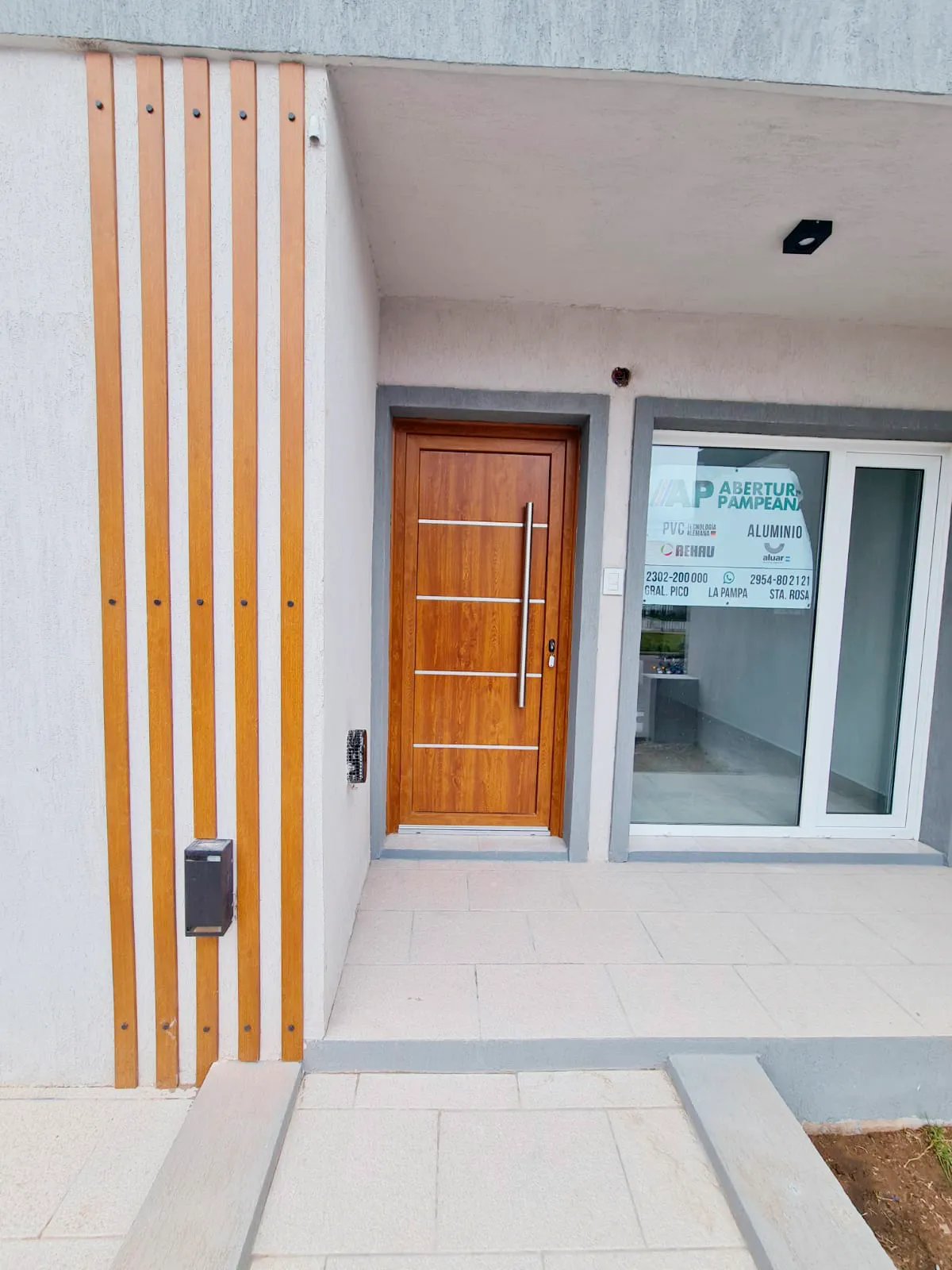 Acceso con puerta de PVC Roble y parasoles de madera en General Pico