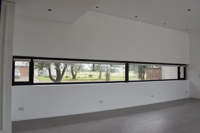 Ventana horizontal apaisada de PVC negro mate en el living