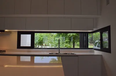 Ventana esquinera de PVC negro mate sobre la mesada de la cocina