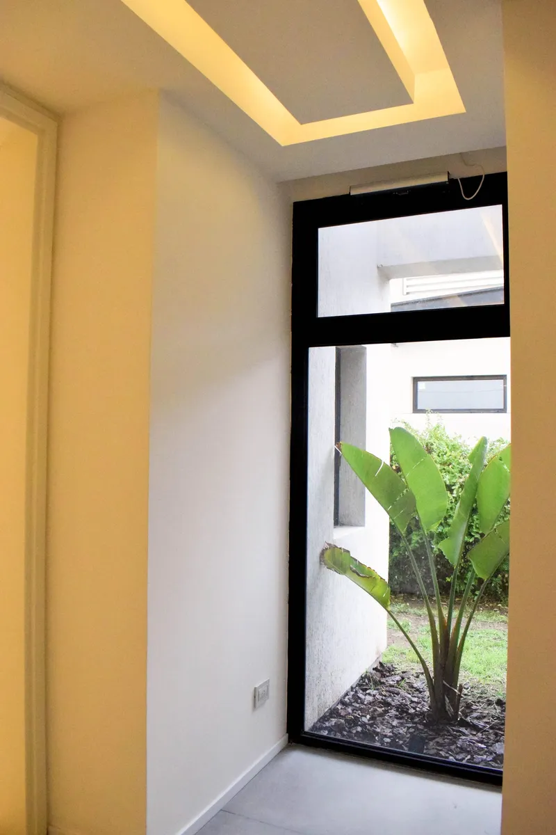 Paño fijo de PVC negro mate de piso a techo hacia el patio interno
